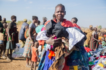 Una donna riunitasi per ricevere dei vestiti