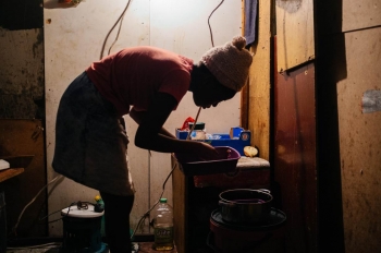 Una donna lava le stoviglie nel centro di Johannesburg 