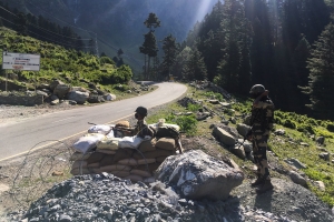 Indian troops position themselves on a road near the Line of Actual Control