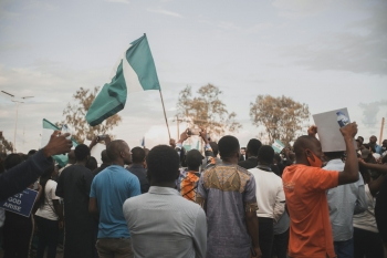 People gathering in a field with flags during daytime