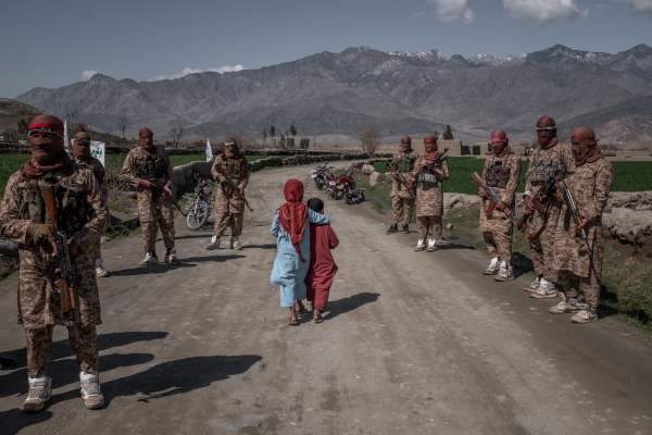 Two boys pass members of a Taliban elite force 