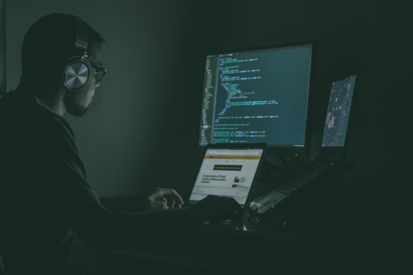 Ragazzo che programma con il pc al buio