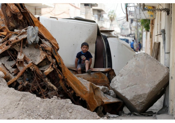 Bambino seduto sullo macerie a Mosul
