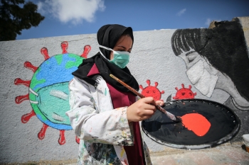 Palestinian artist paints a mural to promote preventive measures against COVID-19, Khan Yunis