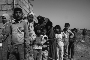 Bambini in fila dietro il filo spinato 