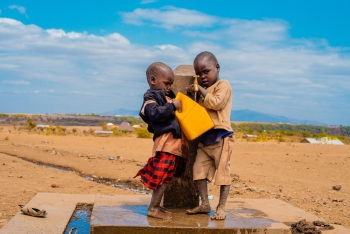 Children near a fountain to collect water