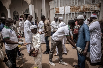 Il personale di sicurezza esegue la scansione e offre disinfettante ai devoti che frequentano moschee nel Burkina Faso  