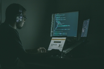 Boy programming on the pc in the dark