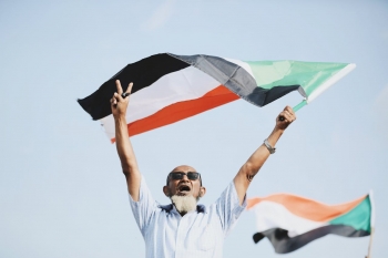 Uomo sventolando la bandiera sudanese