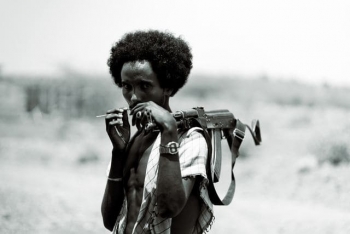 Portrait of an adult man holding a rifle
