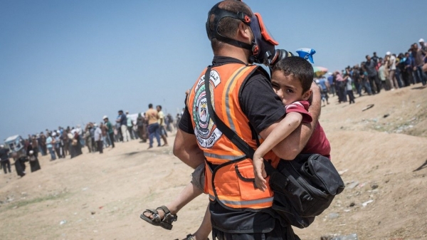 Un bambino palestinese viene trasportato in ambulanza, Gaza, 2018