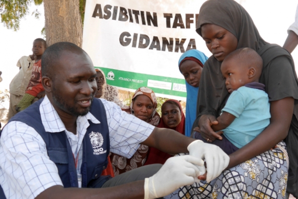 A World Health Organization doctor giving vaccination to a child