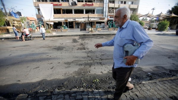 A man walks in front of the ice cream shop the morning after the blast 