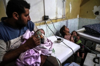 Un padre e una madre tengono i loro bambini malati in un ospedale improvvisato nel Ghouta orientale in Siria, luned&igrave; scorso, gennaio 22