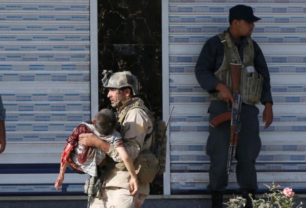 An injured young boy is carried out from the mosque by a member of Afghan special forces