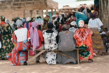 Women in colorful clothes sitting on a bench outdoors