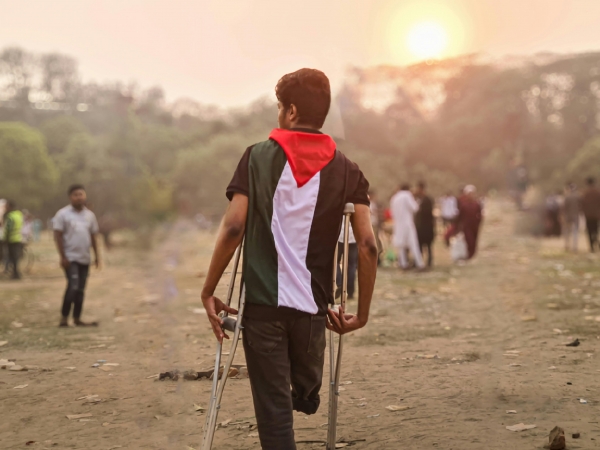 Giovane uomo con disabilit&agrave; che indossa la bandiera della Palestina
