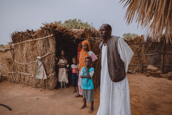 Famiglia accanto alla propria casa di paglia in Sudan