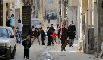 Persone in una strada del campo profughi di Al Hussein ad Amman, Giordania, 2014.