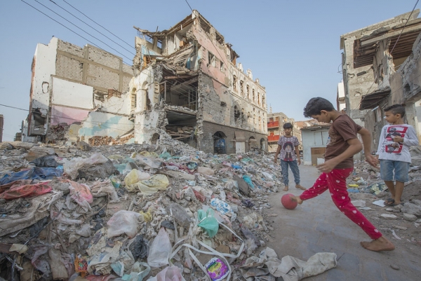 Yemeni children play in the rubble of buildings destroyed in an air raid