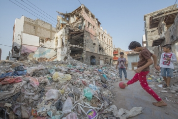 Yemeni children play in the rubble of buildings destroyed in an air raid