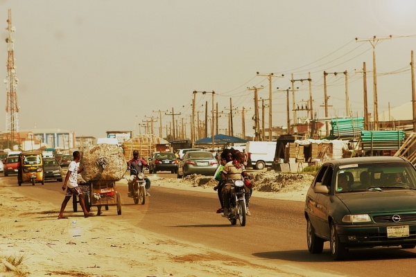 Busy road with people on motorbikes and cars