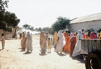 A group of women walking along a dirt road
