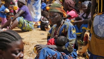 Una giovane madre con il figlio in attesa della distribuzione degli aiuti