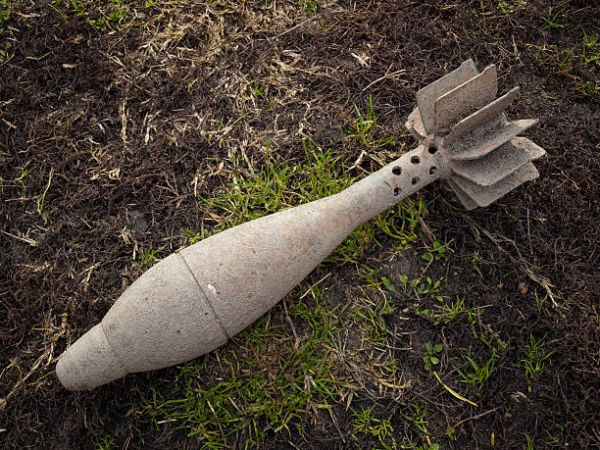An old unexploded mortar round  lying on the ground