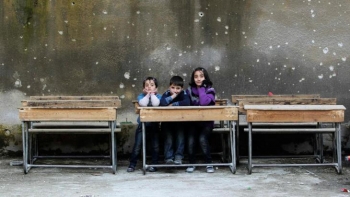 Syrian children in old schoolroom destroyed by bullets