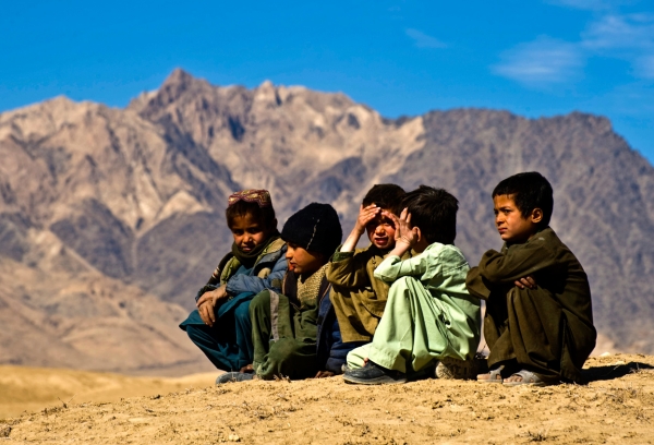 Afghan refugee children sitting on the top of a hill
