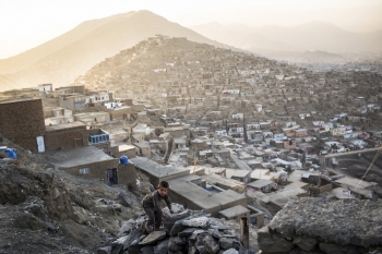 A boy climbs a rock in Kabul