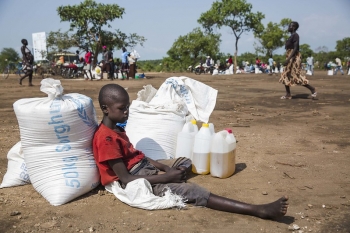 Un bambino sudanese con la sua razione mensile di cibo in un campo profughi