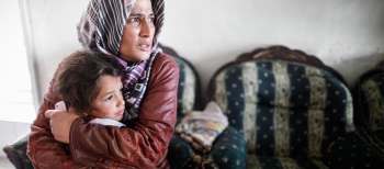 A worried Syrian woman protecting a little girl