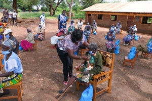 Anziani aspettano il loro turno per la vaccinazione, rispettando il distanziamento sociale e indossando le mascherine (Kenya).