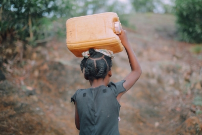 Bambina che porta una brocca d&rsquo;acqua sulla testa