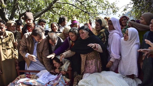 Parenti e amici piangono vicino ai corpi delle vittime dei bombardamenti transfrontalieri nella valle del Neelum in Pakistan