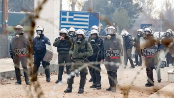 Uomini della polizia greca in piedi al confine per evitare l&rsquo;entrata dei migranti 
