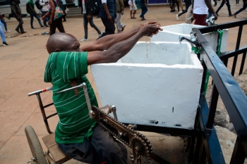 Un uomo in sedia a rotelle si lava le mani in Kenia, seguendo le direttive dell’OMS contro il coronavirus 