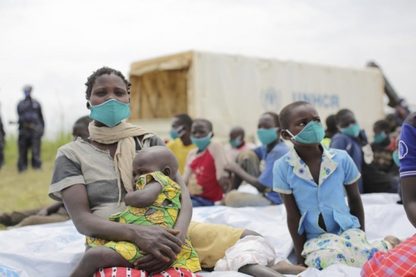 Anurith,richiedente asilo congolese insieme ai suoi figli dopo aver effettuato uno screening test a Zombo, Uganda