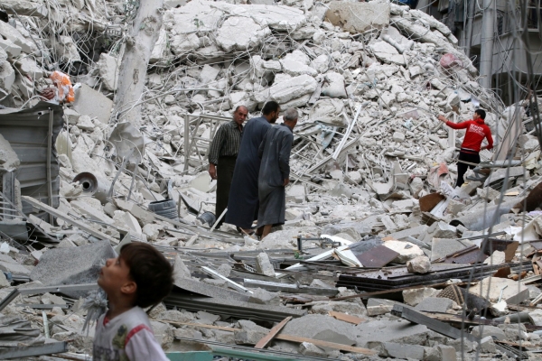 People inspect a damaged site after reported airstrikes on the rebel held Tariq al-Bab neighborhood of Aleppo, Syria, on Sept. 23, 2016. 