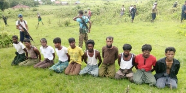 Dieci uomini musulmani Rohingya mentre sono tenuti prigionieri dai soldati del Myanmar prima dell'esecuzione.