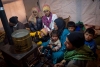 A Syrian refugee family gathered around a stove inside their shelter in Lebanon&rsquo;s Bekaa Valley.