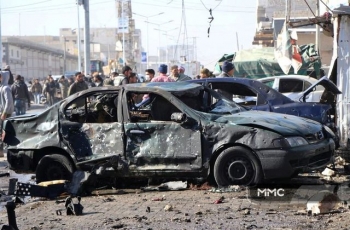 A series of incernarted cars are inspected by residents of Al-Bab in the aftermath of the November 22nd bombing