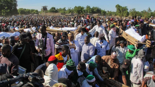Inhabitants of Koshobe attend the funeral of the farm workers killed