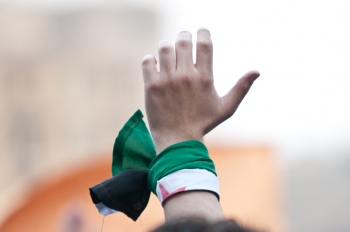 Un manifestante indossa la bandiera siriana 