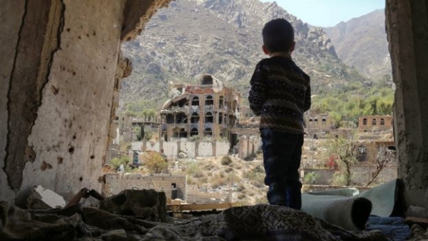 Un bambino Yemenita osserva una città distrutta 