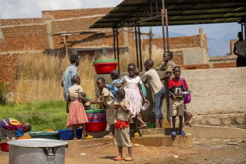 La foto ritrae le condizioni igieniche a cui sono sottoposti dei bambini che mangiano e si lavano le mani 