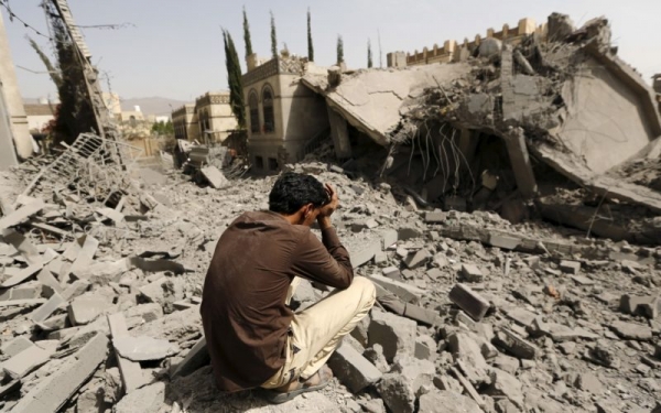 Uomo yemenita contempla le macerie 