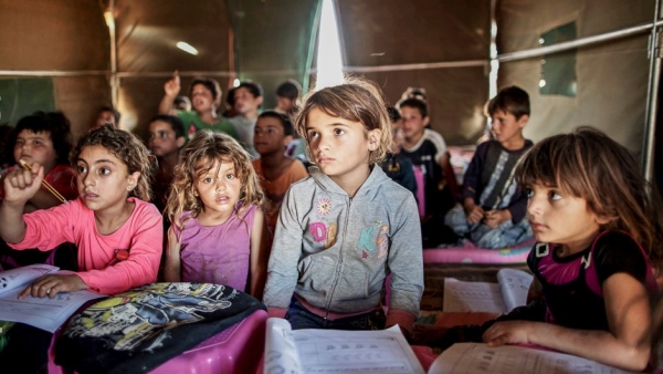 Rifugiati siriani seguono una lezione in un campo profughi a Mafraq, Giordania